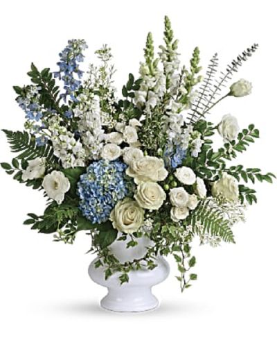 <p>Honor the memory of a cherished loved one with a serene and elegant bouquet that blends soft blue and pure white blooms. This refined arrangement conveys a message of peace, remembrance, and lasting love, thoughtfully presented in a graceful white urn that adds a timeless touch to any setting.</p>
<p>The bouquet features a delicate mix of light blue hydrangea, white roses, white spray roses, white lisianthus, light blue delphinium, white snapdragons, white stock, and white waxflower. These blossoms are complemented by accents of huckleberry, variegated ivy, spiral eucalyptus, dagger fern, and lemon leaf, providing a textured and natural depth. The combination creates a full, balanced design that reflects beauty and grace while evoking a sense of calm and dignity.</p>
<p>Presented in a white designer urn, this arrangement is an ideal tribute for memorial services, funerals, or sending heartfelt condolences directly to family and friends. Its soft hues and gentle form offer solace and hope during difficult times, serving as a meaningful expression of sympathy and enduring affection.</p>
<p>Each bouquet is carefully handcrafted with attention to detail, ensuring every element is fresh and thoughtfully arranged. The elegant urn adds a lasting keepsake quality, making this arrangement a treasured remembrance for years to come. Personal messages of sympathy can be added to provide a deeper connection and heartfelt support.</p>
<p>Sending this bouquet offers more than flowers; it provides comfort, love, and a beautiful way to honor a life well lived. This tribute stands as a symbol of peace and enduring remembrance, perfect for those wishing to express their condolences with dignity and grace.</p>